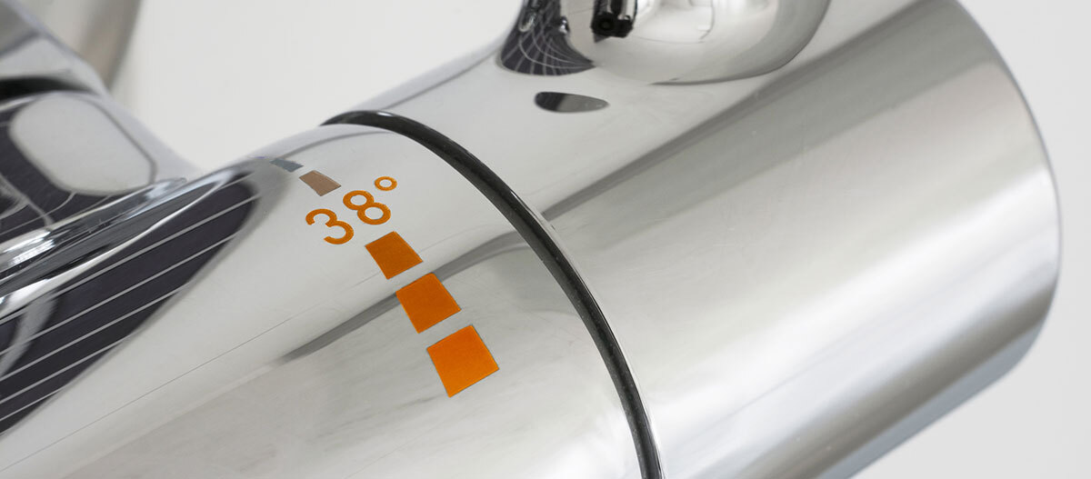 Nahaufnahme eines modernen verchromten Wasserhahngriffs mit Temperaturanzeige bei 38 Grad Celsius.