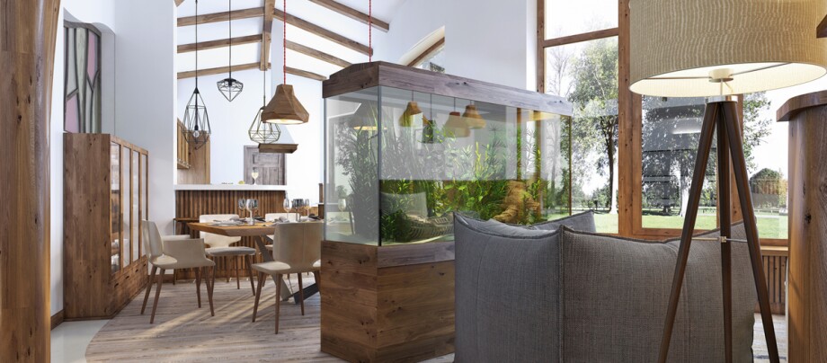 Ein Aquarium steht im Wohnraum. Moderner Wohn- und Essbereich mit großem Aquarium, Holzmöbeln und großen Fenstern mit Blick auf die Natur.