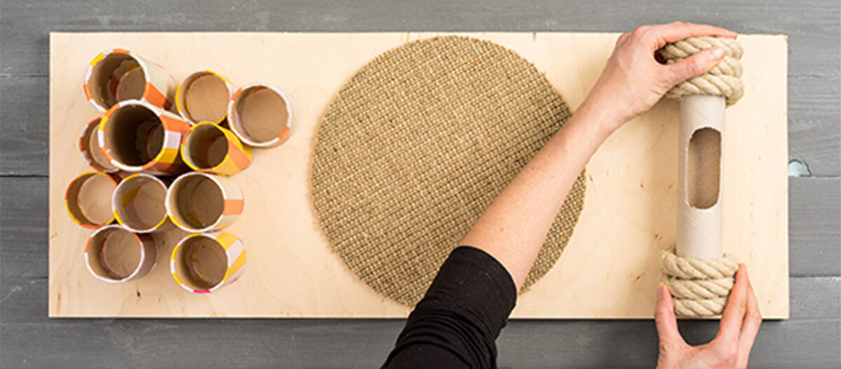 Anleitung DIY Spielzeug für Katzen DIY Katzenkratzbrett mit Papprollen, Sisalmatte und Seil, Bastelprojekt auf Holzbrett
