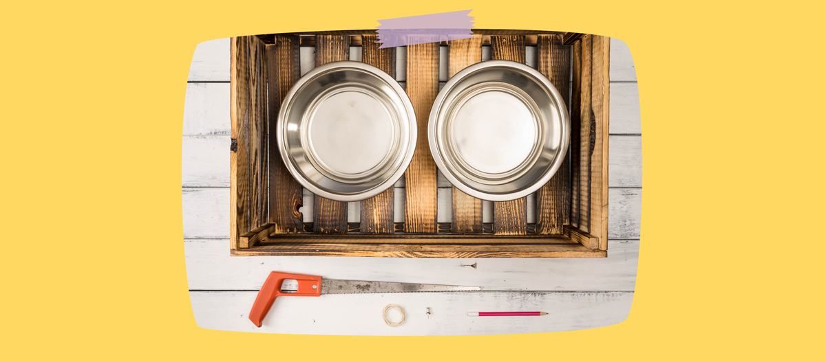 Holzkiste mit zwei Edelstahl-Hundenäpfen und Werkzeug für DIY-Hundefutterstation