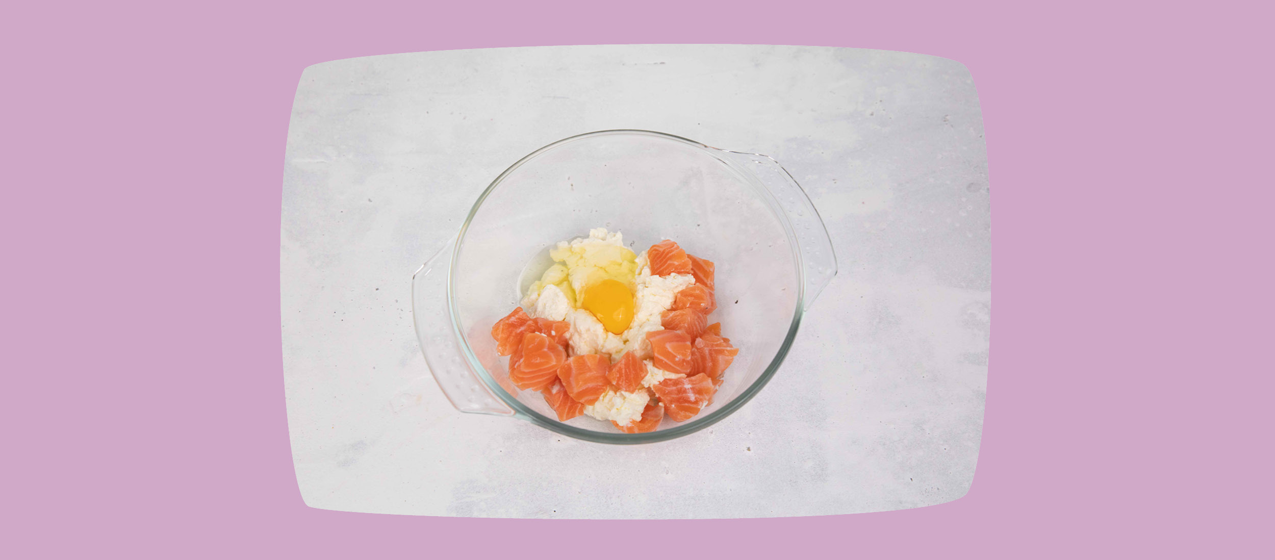 Glasrührschüssel mit rohem Lachs, Ei und Hüttenkäse auf hellem Untergrund